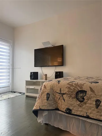 a bedroom with a bed and a flat screen tv