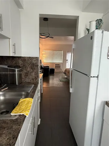 a view of a kitchen with a sink and refrigerator