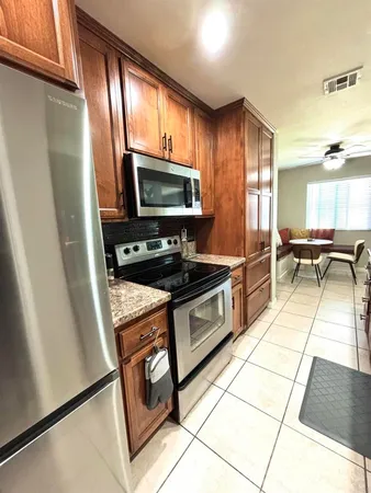 a kitchen with granite countertop a stove a microwave a sink and cabinets