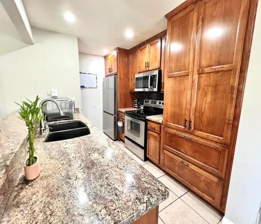 a kitchen with granite countertop a refrigerator and a sink