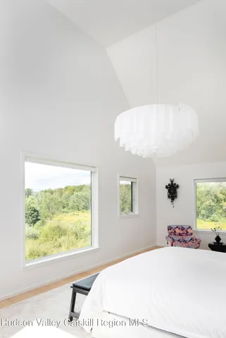 a bedroom with a bed and a large window