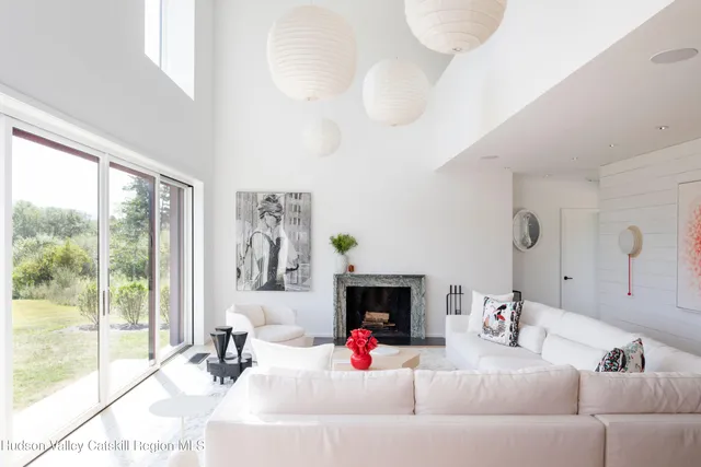 a living room with furniture a fireplace and a large mirror