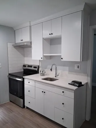 a kitchen with cabinets appliances and a sink
