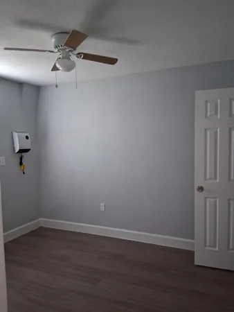 a view of an empty room with wooden floor