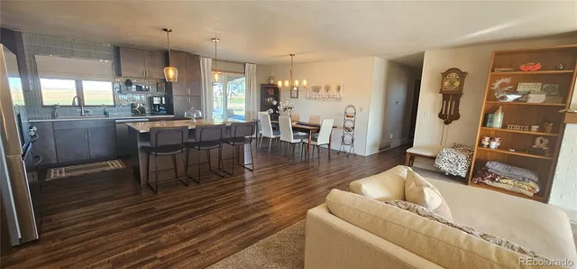 a living room with furniture a wooden floor and next to a window