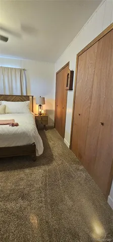 a bedroom with a bed and a refrigerator