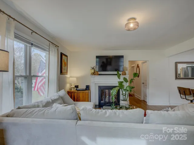 a living room with furniture a fireplace and a flat screen tv