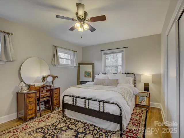 a bedroom with a bed a chandelier and dresser