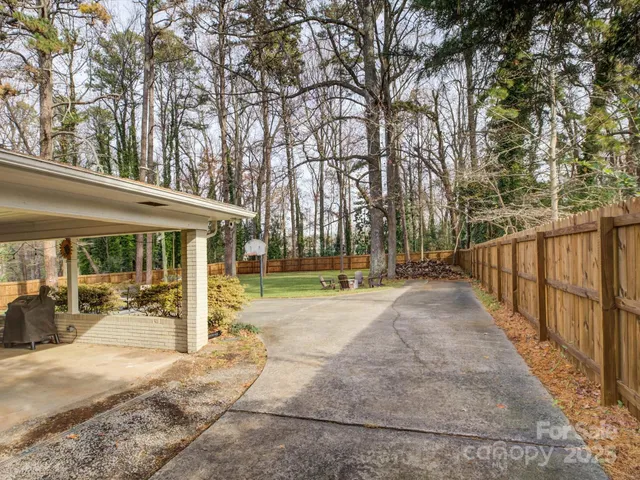 a view of a house with backyard and trees