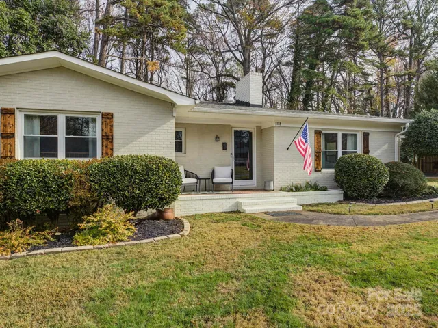 a front view of house with yard and trees around