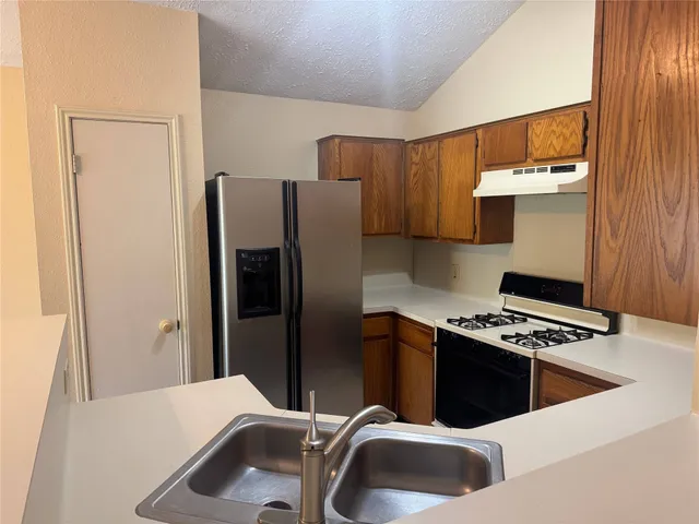a kitchen with stainless steel appliances a stove a refrigerator and a sink