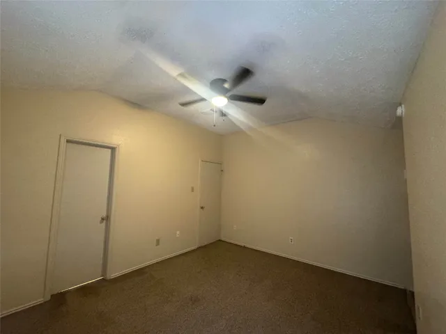 an empty room with a ceiling fan and a window