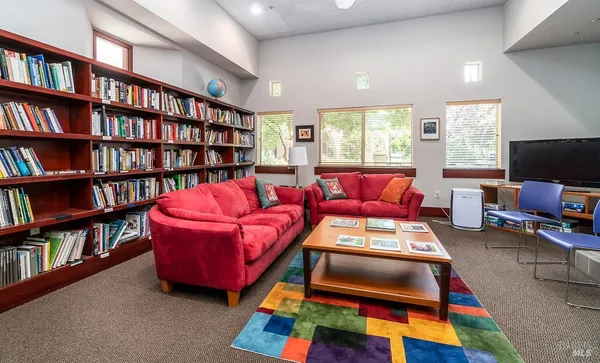 a living room with furniture and a book shelf