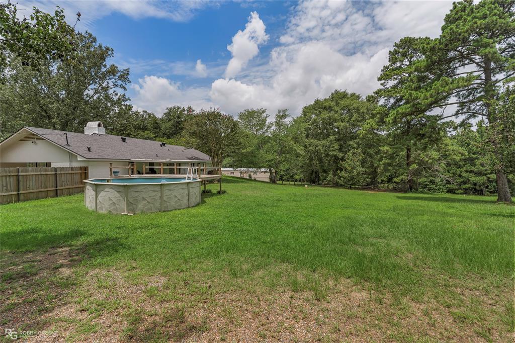 1426 Caney Lake Road Minden, LA 71055 - Photo 28 of 36 Expansive backyard featuring a large above-ground pool, wood privacy fencing, and mature trees bordering the property