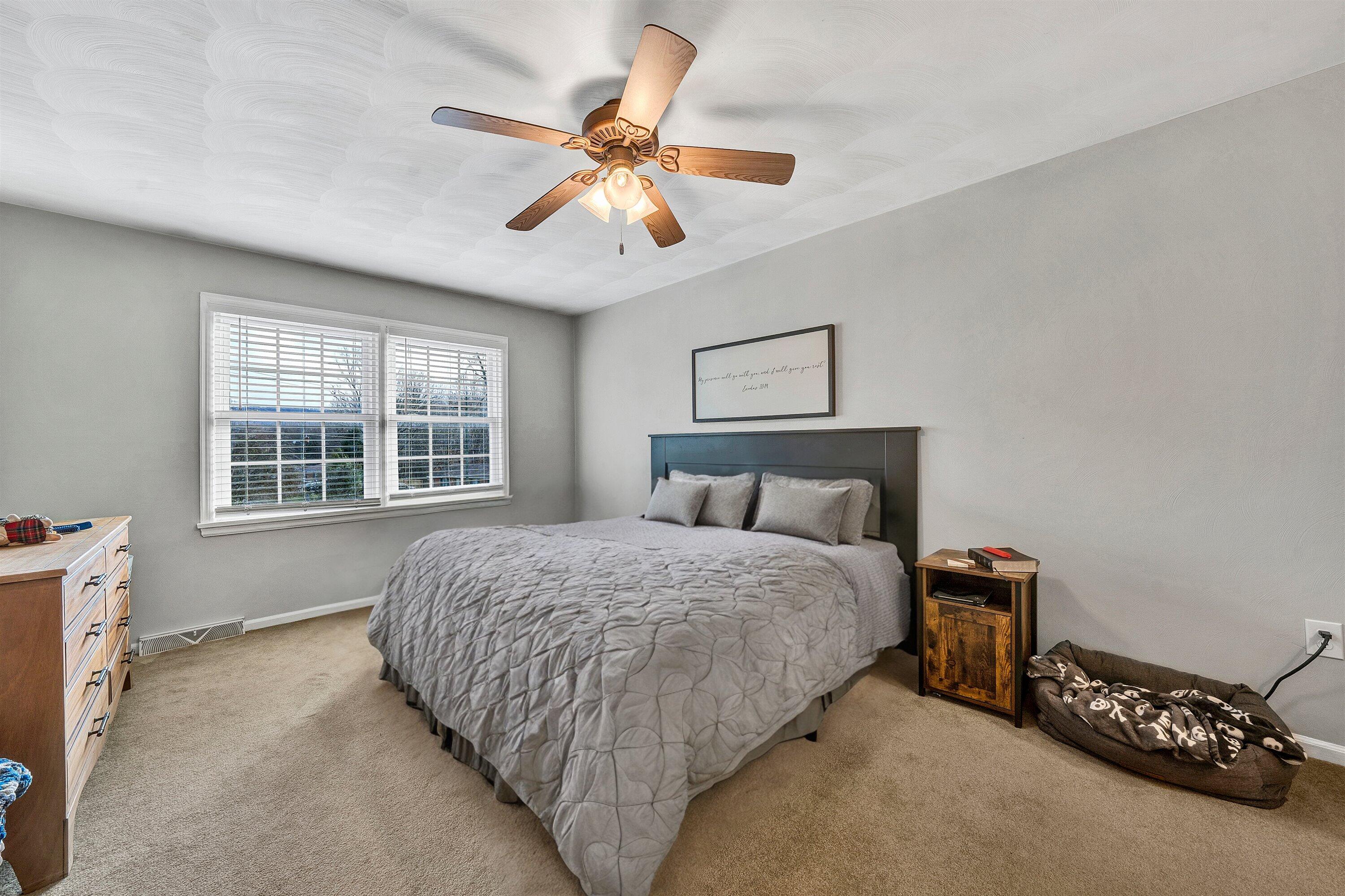25 Charmwood Drive Blue Ridge, VA 24064 - Photo 20 of 35 a bedroom with a bed and a chandelier