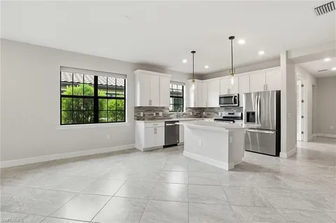 a kitchen with a white appliances cabinets and a counter top space