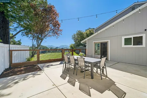 a patio with table and chairs and potted plants