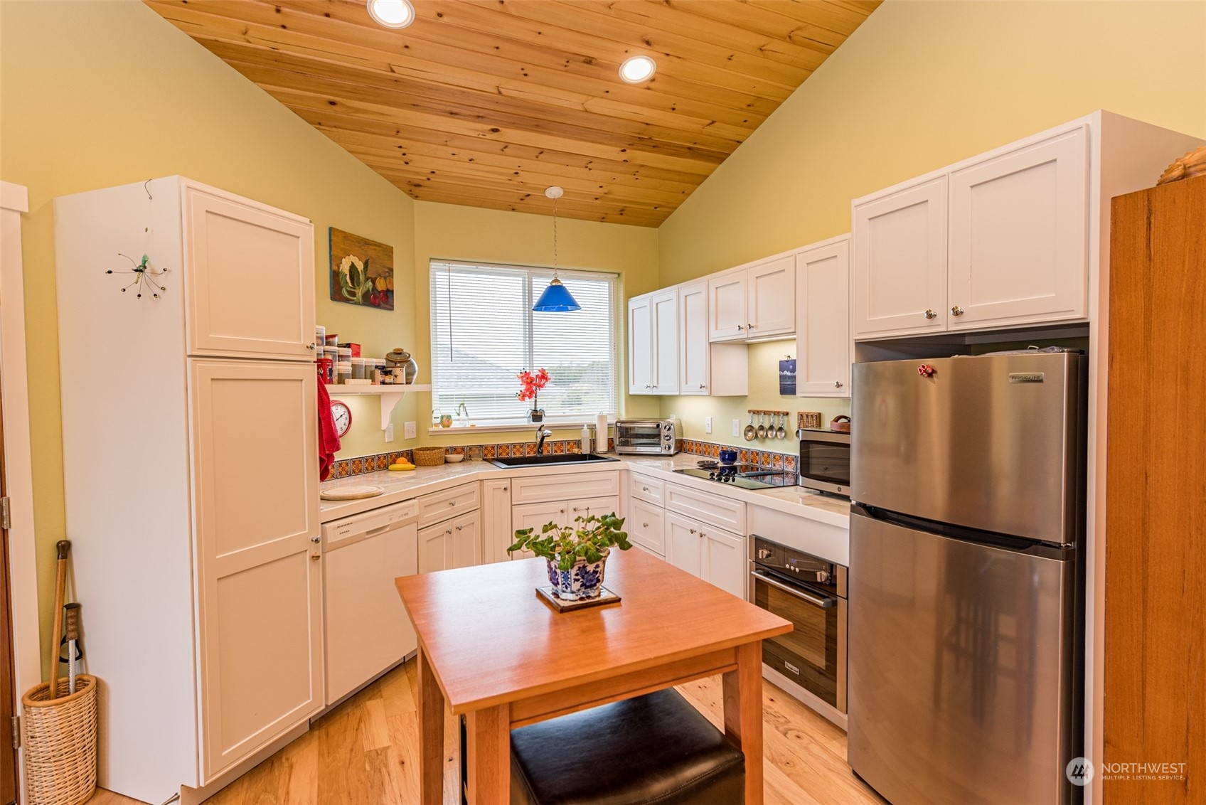 400 Ridge View Drive Sequim, WA 98382 - Photo 13 of 40 a kitchen with stainless steel appliances a refrigerator a stove a sink dishwasher and white cabinets with wooden floor