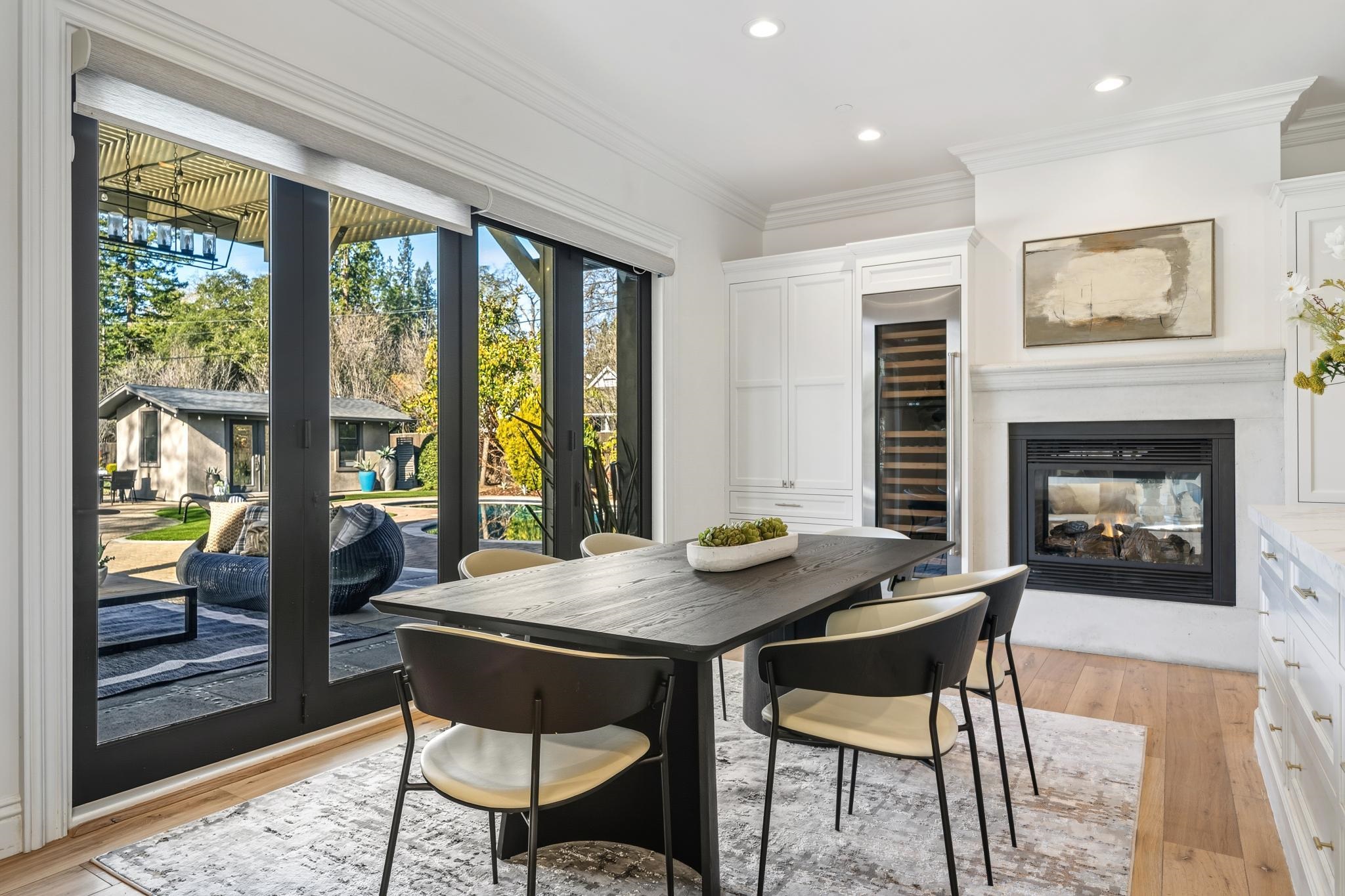 3957 Rancho Road Lafayette, CA 94549 - Photo 18 of 60 Dining space featuring beverage cooler, light wood-type flooring, crown molding, a multi sided fireplace, and recessed lighting