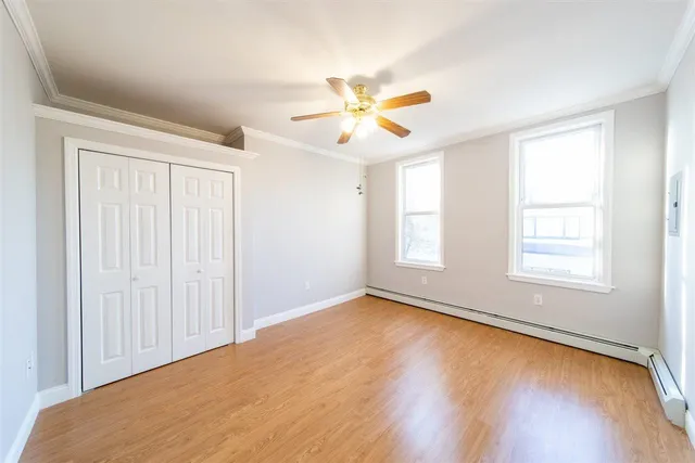 a view of a hallway with wooden floor and entryway