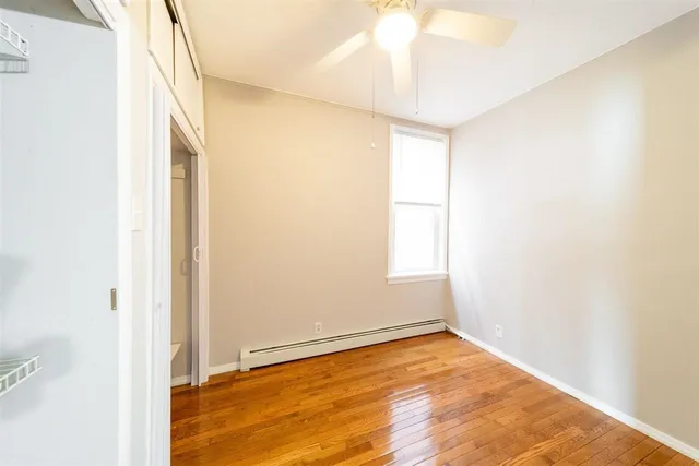 a view of a big room with wooden floor and a ceiling fan