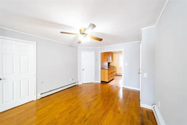 a view of a livingroom with wooden floor and a ceiling fan
