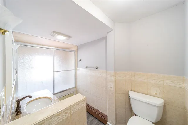a bathroom with a granite countertop toilet sink and shower