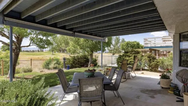 a view of a patio with table and chairs and floor to ceiling window with wooden floor