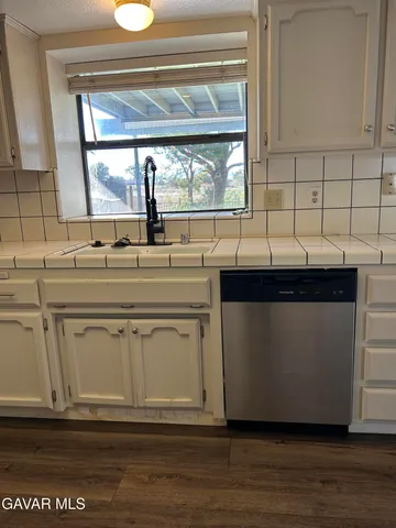 a view of a kitchen with wooden floor and electronic appliances