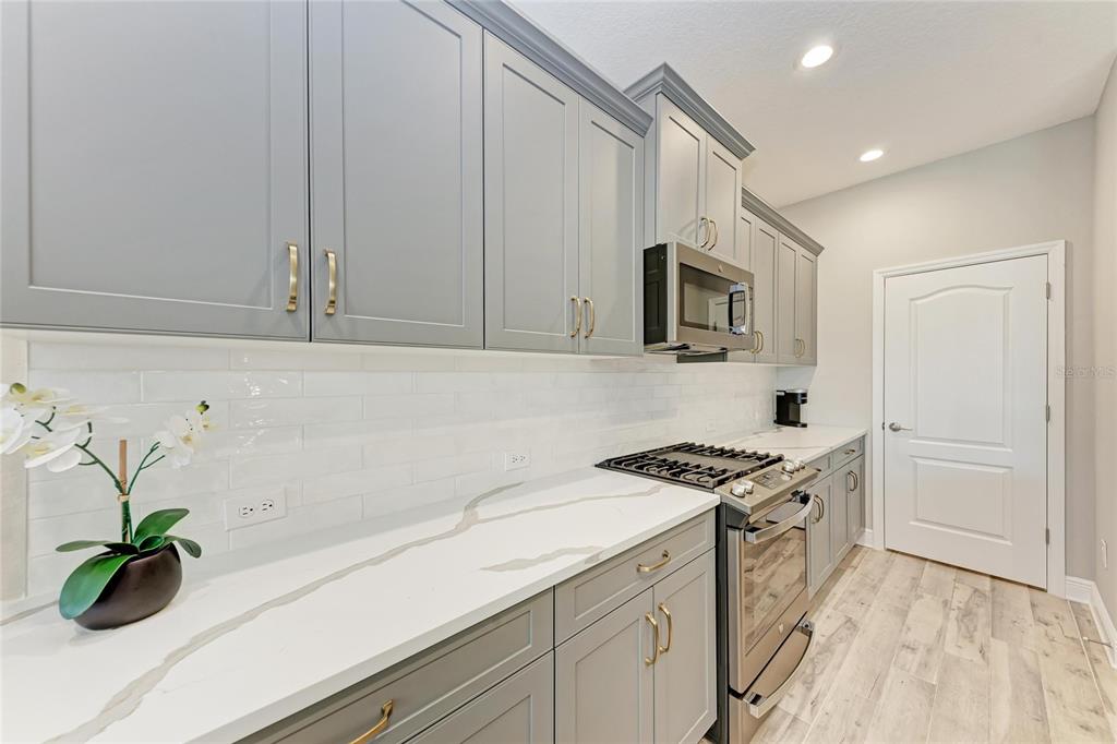 4211 Rustling Pines Terrace Parrish, FL 34219 - Photo 16 of 87 a kitchen with granite countertop a sink a stove and cabinets