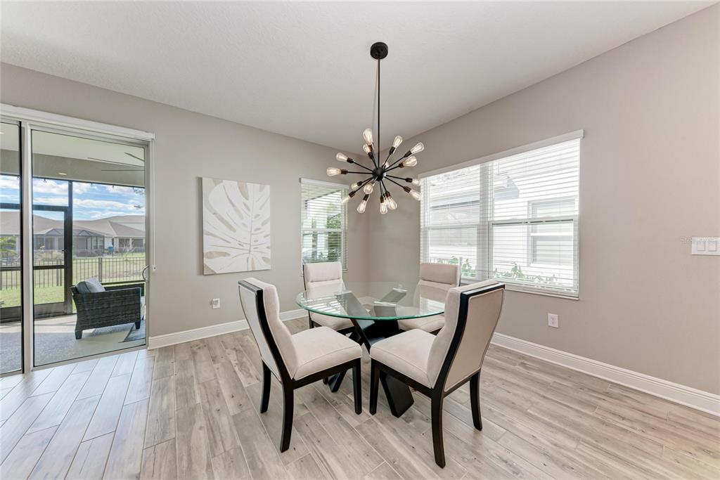 4211 Rustling Pines Terrace Parrish, FL 34219 - Photo 19 of 87 a view of a dining room with furniture window and wooden floor
