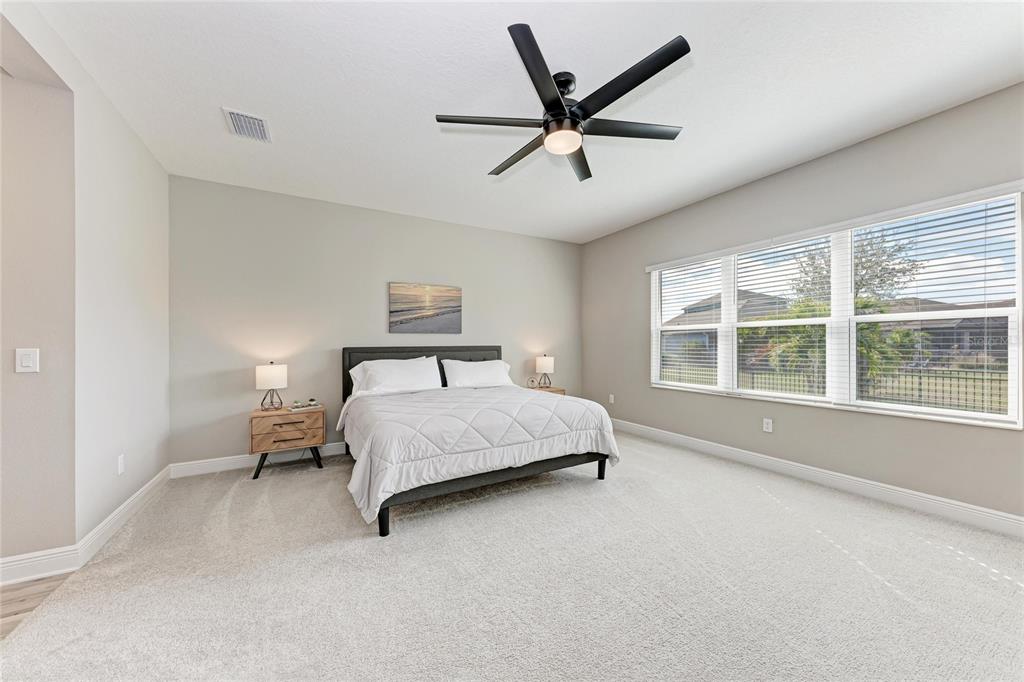 4211 Rustling Pines Terrace Parrish, FL 34219 - Photo 22 of 87 a bedroom with a large bed and a large window