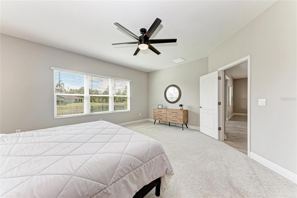 4211 Rustling Pines Terrace Parrish, FL 34219 - Photo 25 of 87 a bedroom with a bed a chair and large window