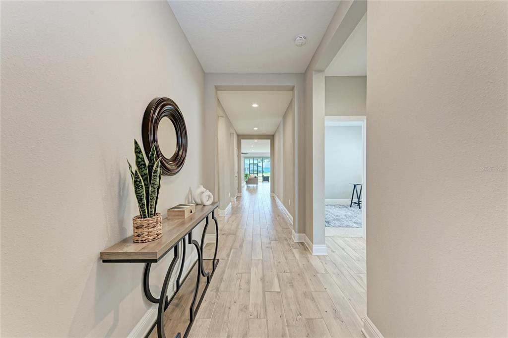4211 Rustling Pines Terrace Parrish, FL 34219 - Photo 7 of 87 a view of a hallway with wooden floor and a bathroom