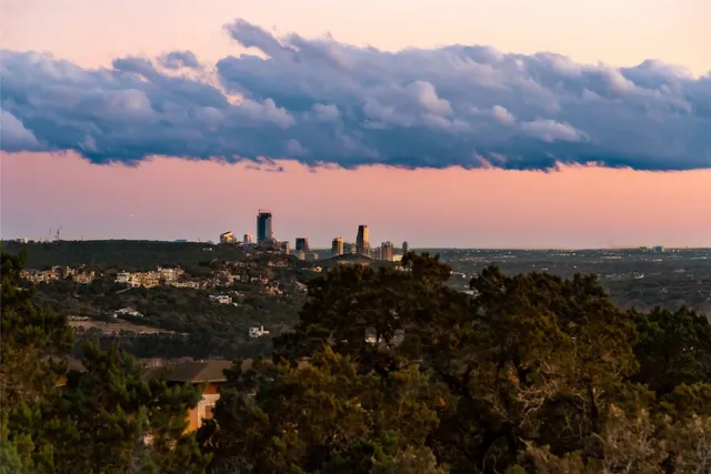 an aerial view of ocean and residential houses with outdoor space