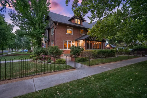 a front view of a house with a yard and potted plants
