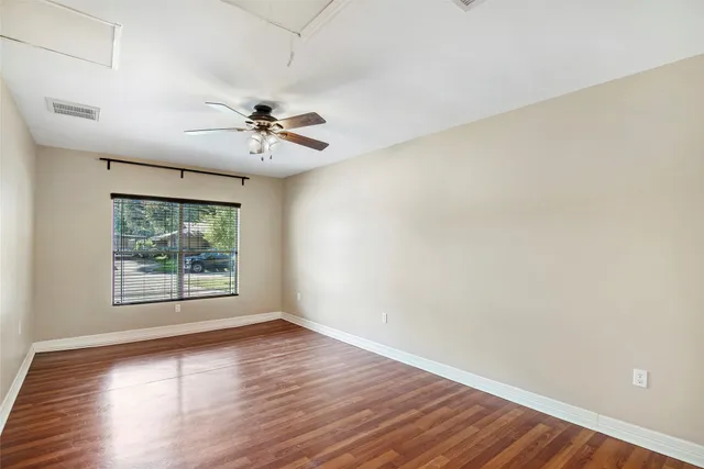 an empty room with kitchen view and natural light