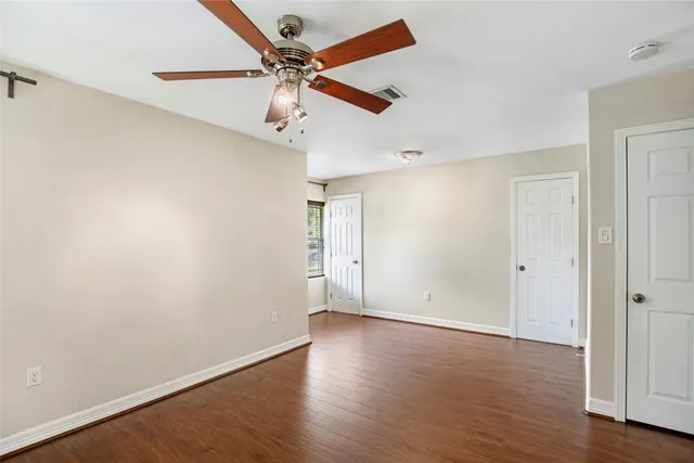 an empty room with a window and a fan