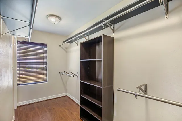 an empty room with wooden floor ceiling fan and windows