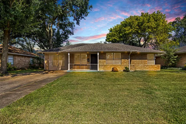 a front view of a house with a garden