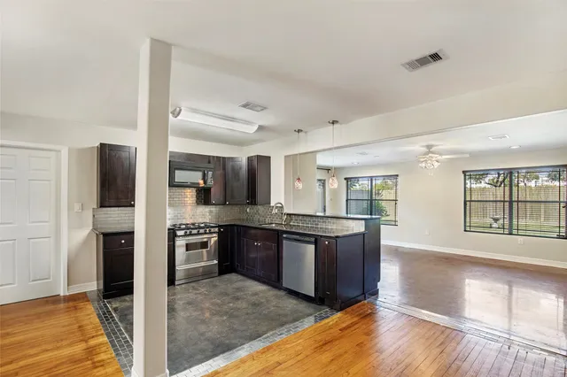 a kitchen with stainless steel appliances granite countertop a refrigerator and a stove top oven