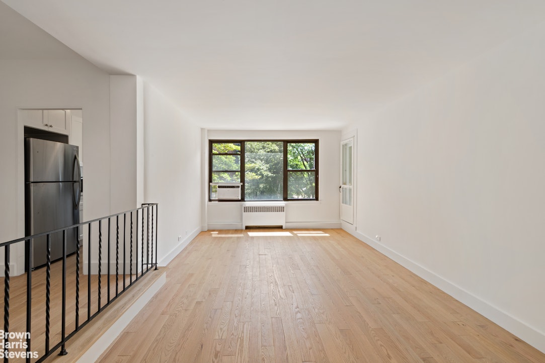 98-41 64th Road, Unit 3G Queens, NY 11374 - Photo 9 of 14 a view of an empty room with wooden floor and a window