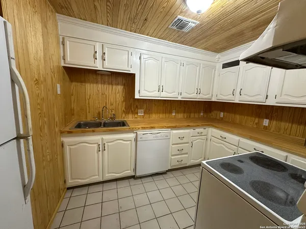 a kitchen with cabinets appliances and a sink