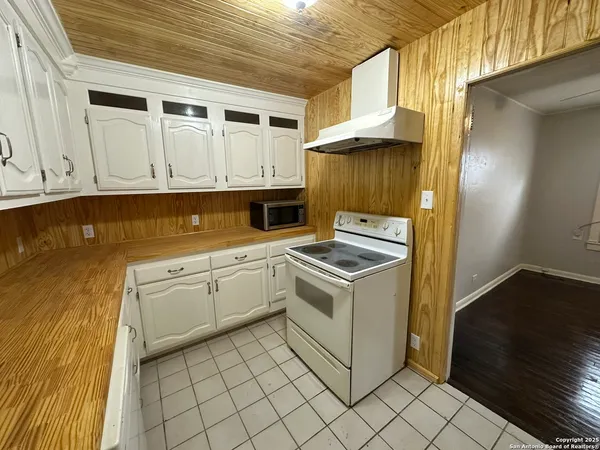 a kitchen with cabinets appliances and wooden floor