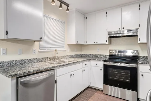 a kitchen with stainless steel appliances granite countertop a stove and a sink