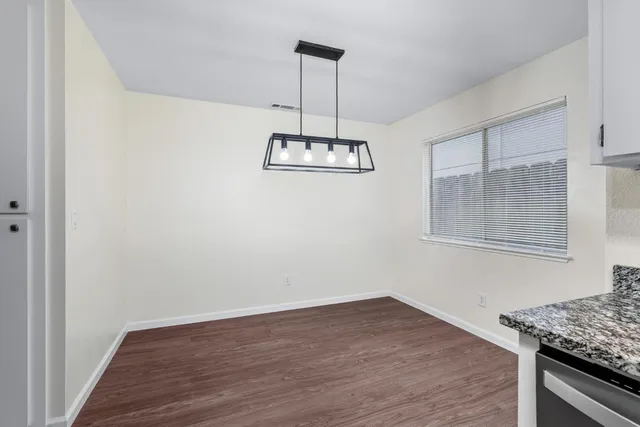a view of a room with wooden floor and kitchen
