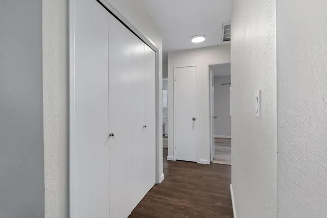 a view of a hallway with wooden floor