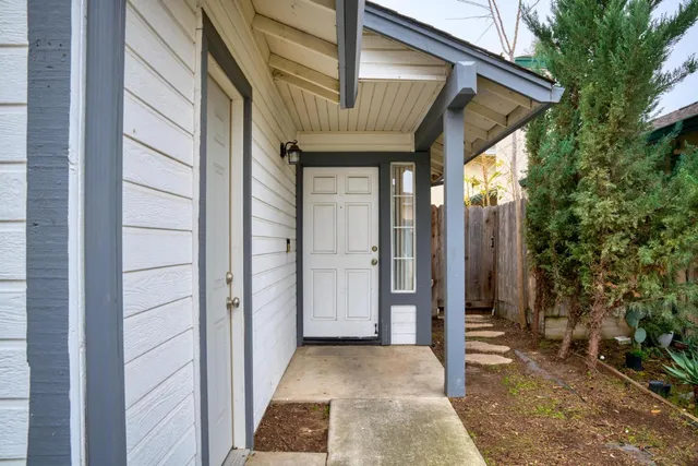 a view of a house with a wooden door and balcony