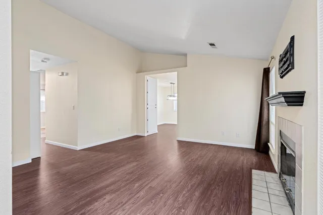 a view of a livingroom with wooden floor and a fireplace