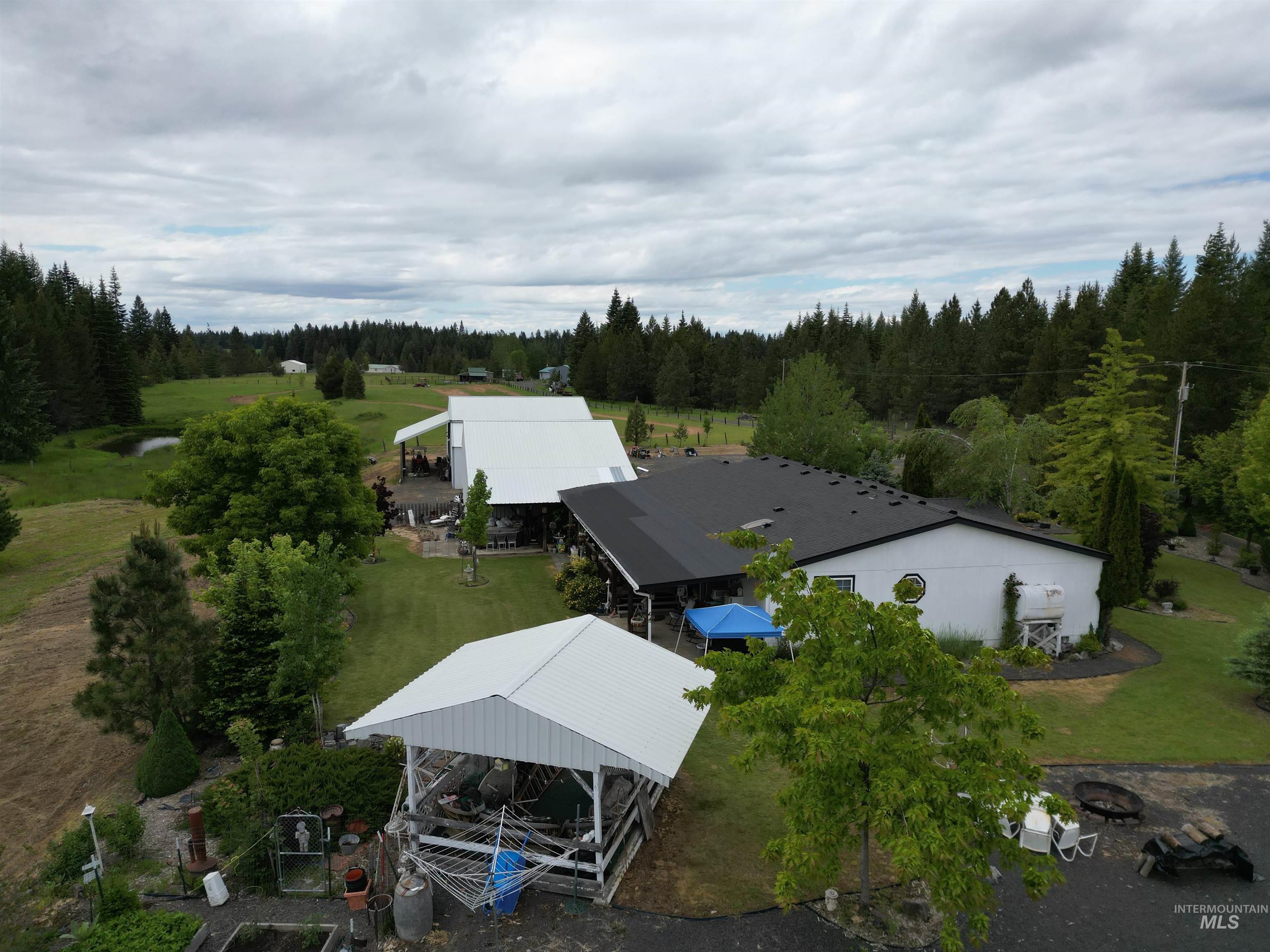 254 Lackey Road Weippe, ID 83553 - Photo 30 of 38 Property featuring multiple structures, including a white building with a dark roofline and an open-sided pavilion with a white roof